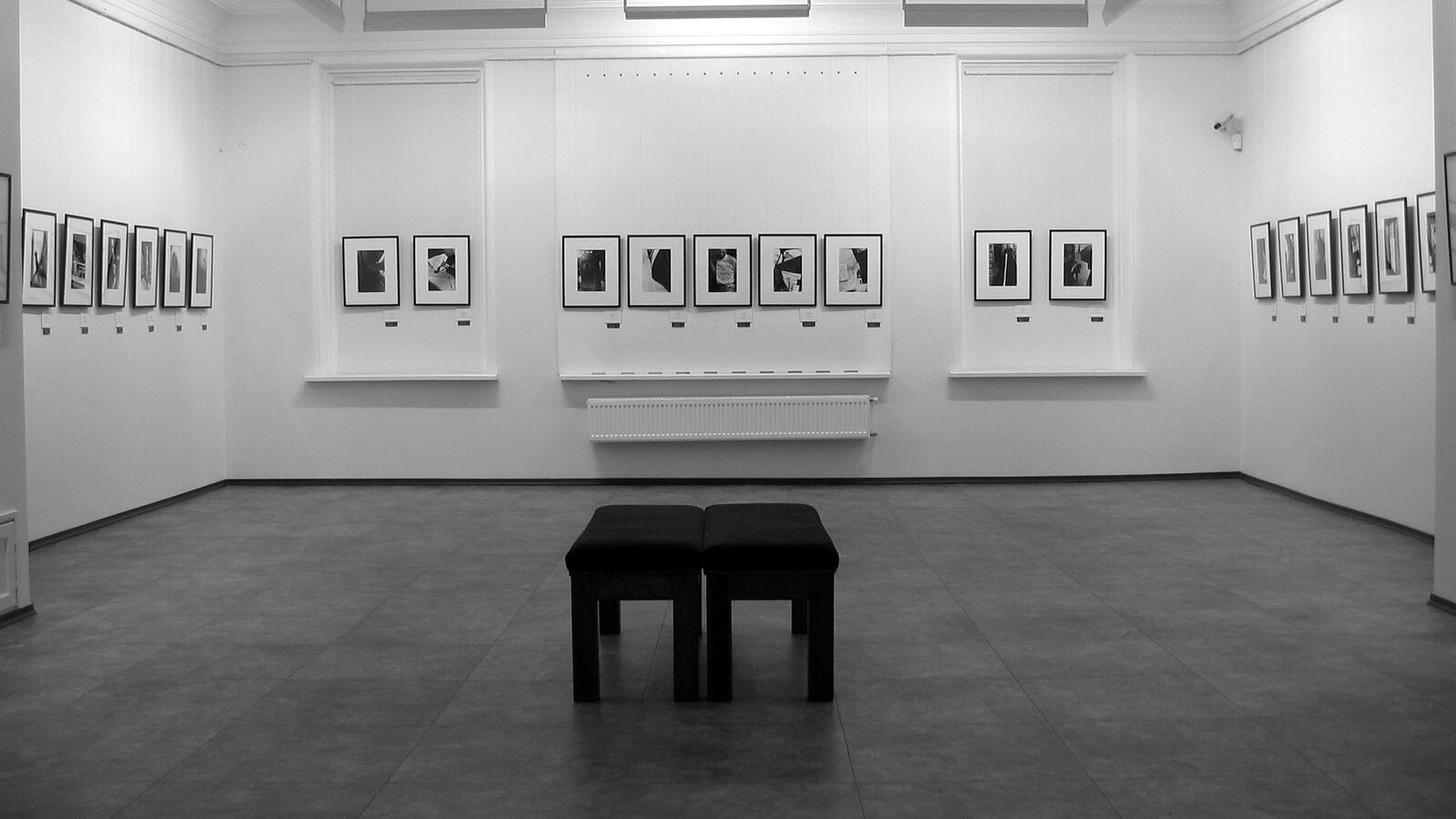 A minimalist contemporary art gallery with framed artworks on white walls, representing the galleries of Alserkal Avenue in Al Quoz, Dubai.