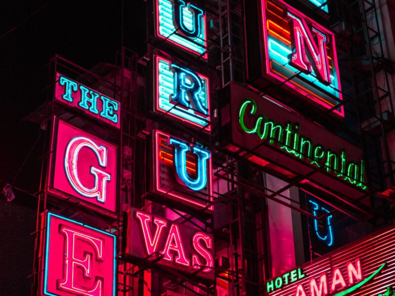 A dense stack of brightly coloured vintage neon signs glowing at night